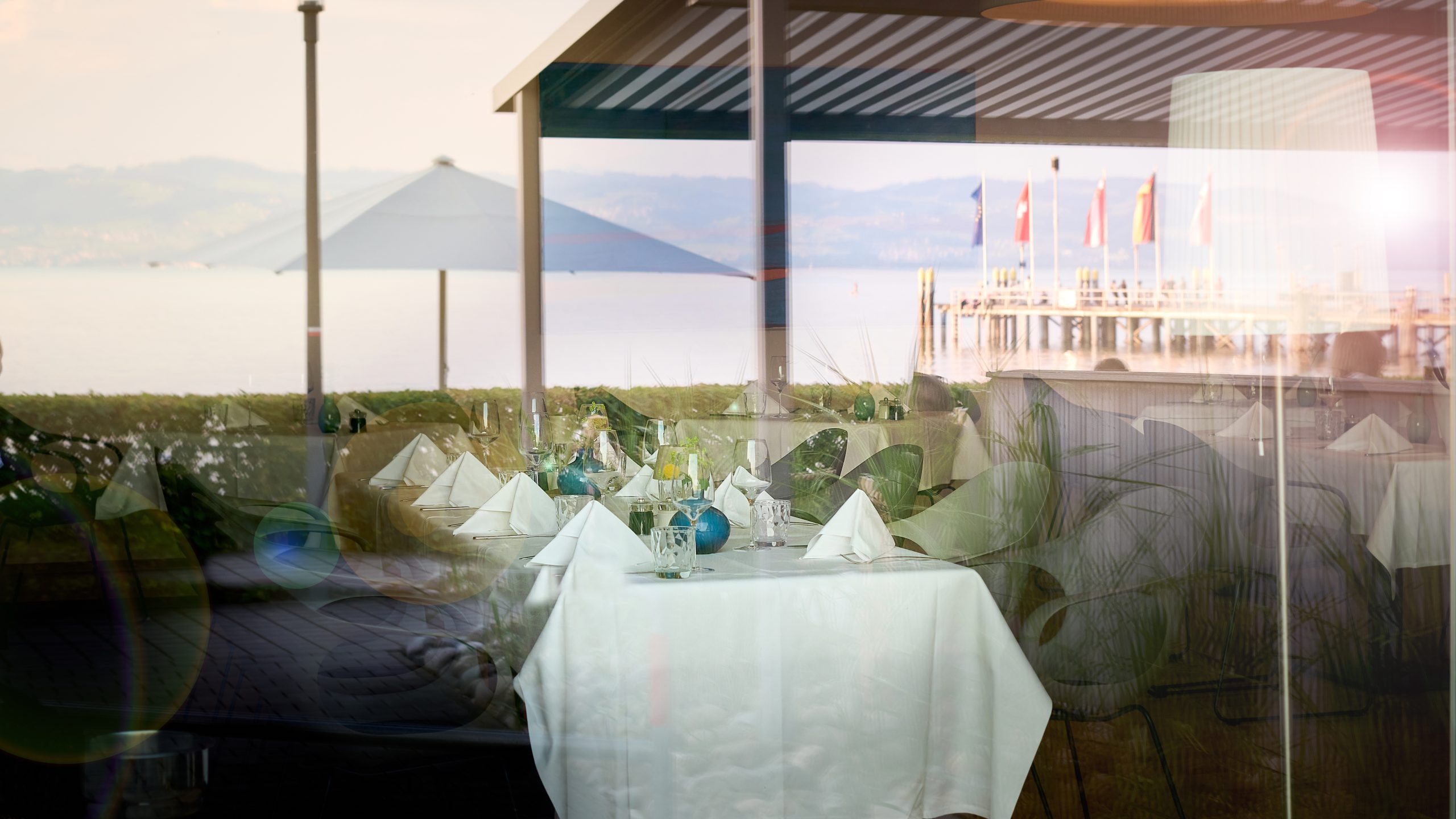 Terrasse des Seehotels mit gedeckten Tischen und Blick auf den Bodensee