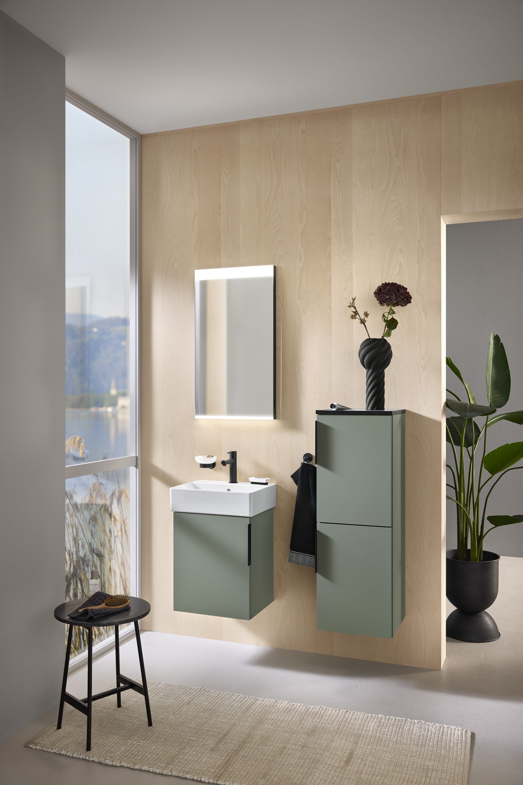 Modernes Gäste-WC mit weißem Waschbecken, Holzverkleidung, Spiegel und Pflanze in hellem Raum.