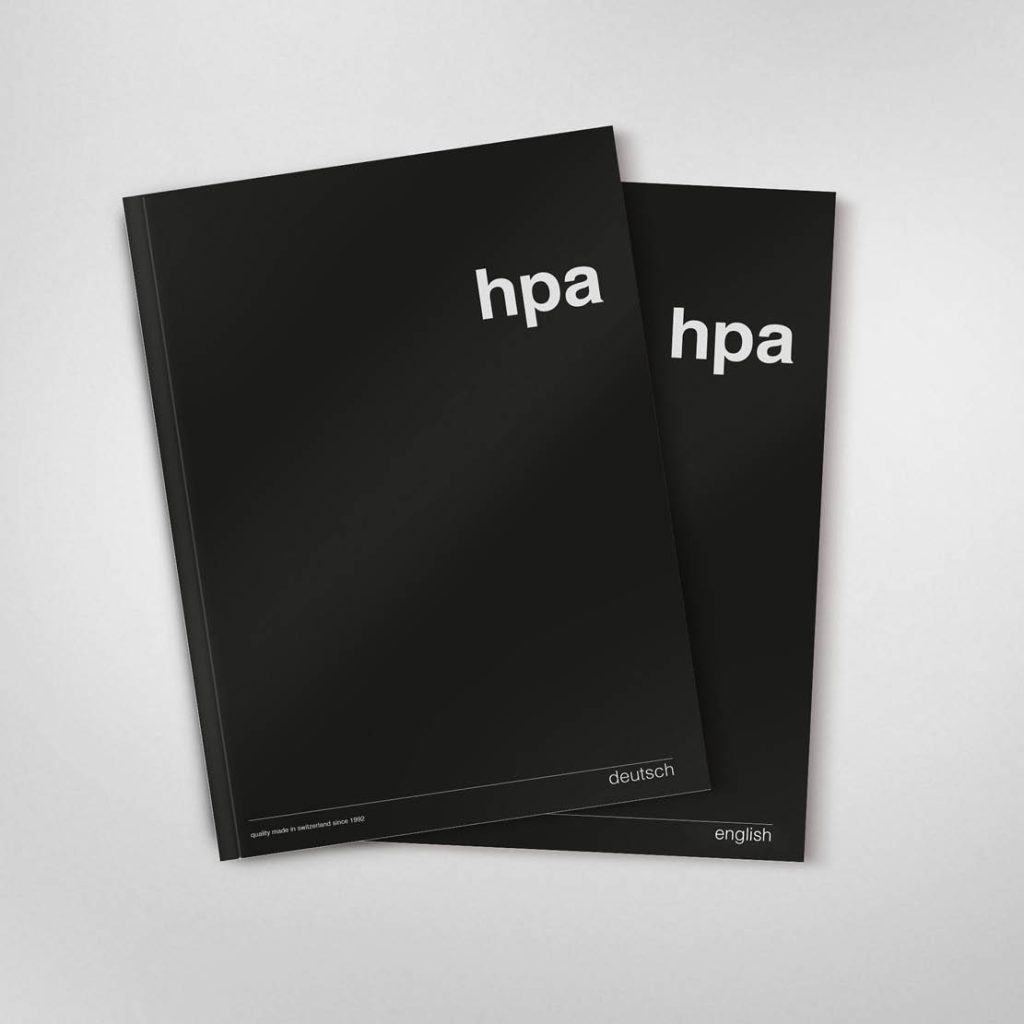 Zwei schwarze Ordner mit weißem Logo „hpa“ und Beschriftungen „deutsch“ und „english“.