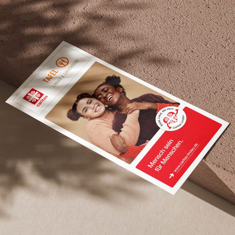 Frau hält schlafendes Baby im Arm vor Plakat „Mensch sein für Menschen“