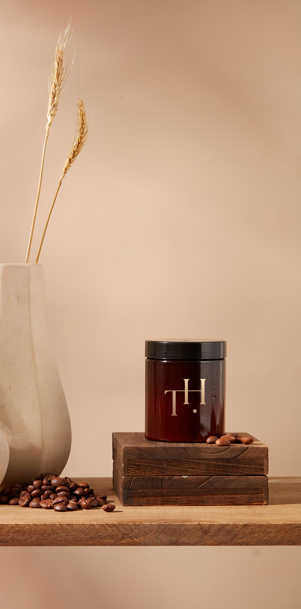 Weiße Vase mit Trockenblumen, daneben Holzkiste mit rotem „TH“ und Nüssen