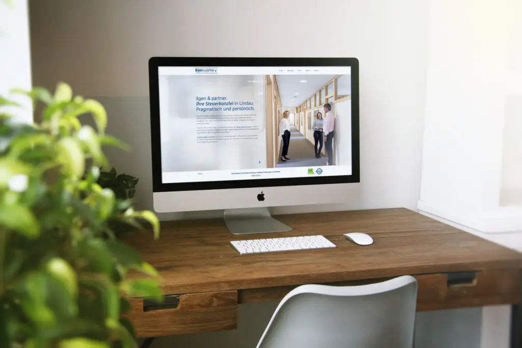 Laptop auf Holzschreibtisch mit geöffnetem Browserfenster der Steuerkanzlei Ilgen & Partner