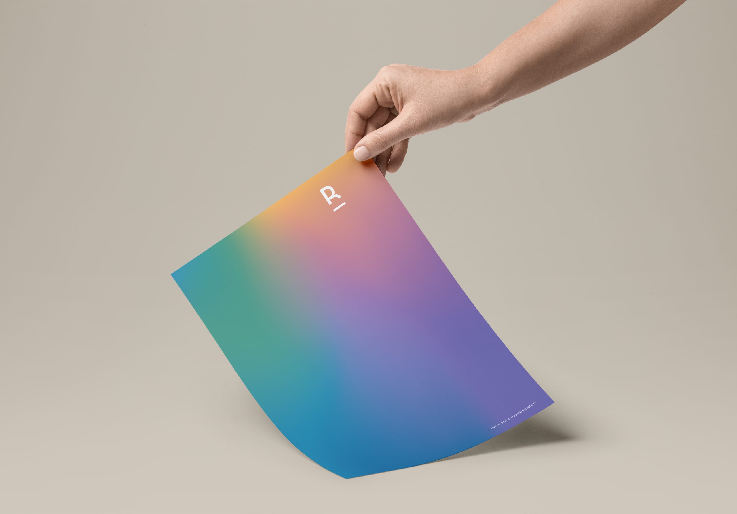 Hand hält weißes Blatt mit blauem R-Logo und Kontaktdaten