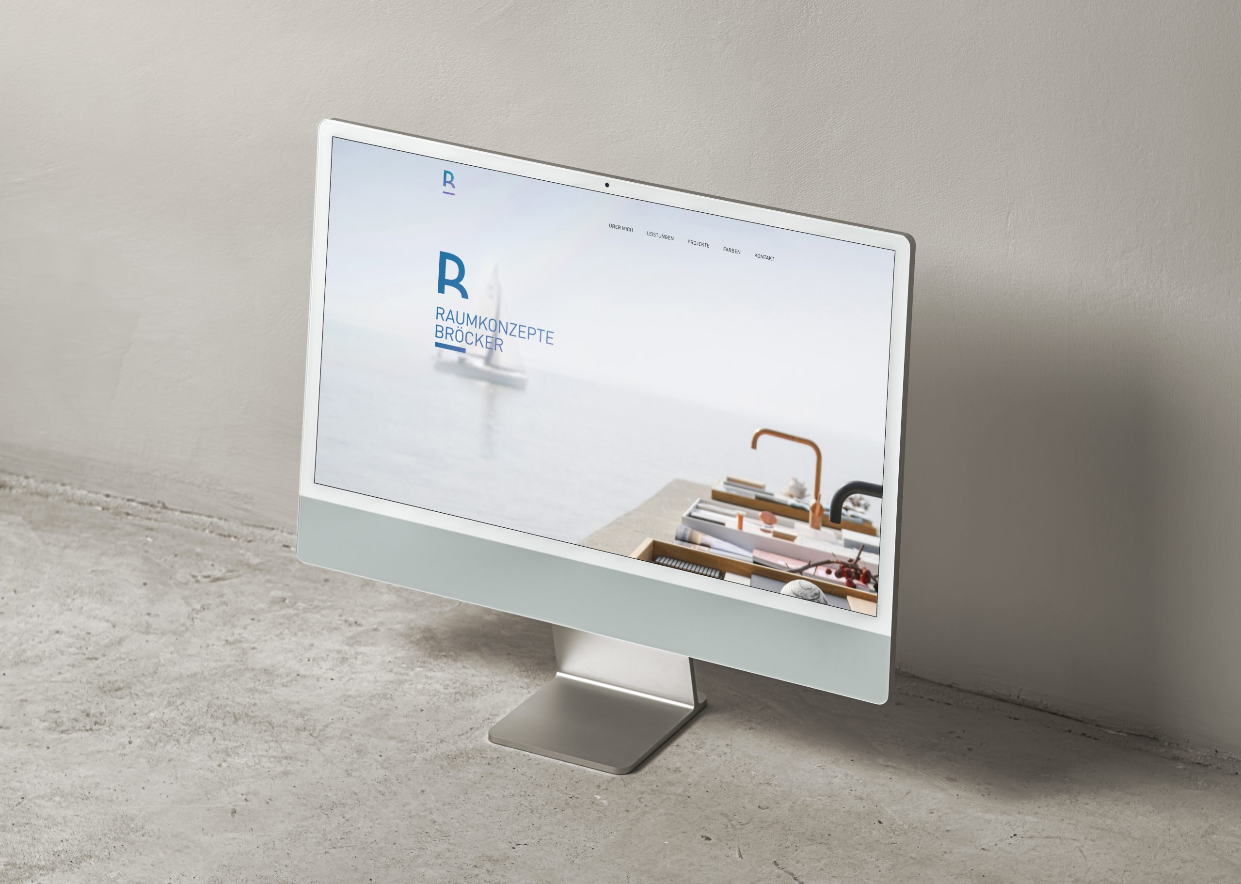 Laptop mit geöffnetem Browserfenster der Website „R RAUMKONZEPTE BRÖCKER“ auf hellem Tisch.