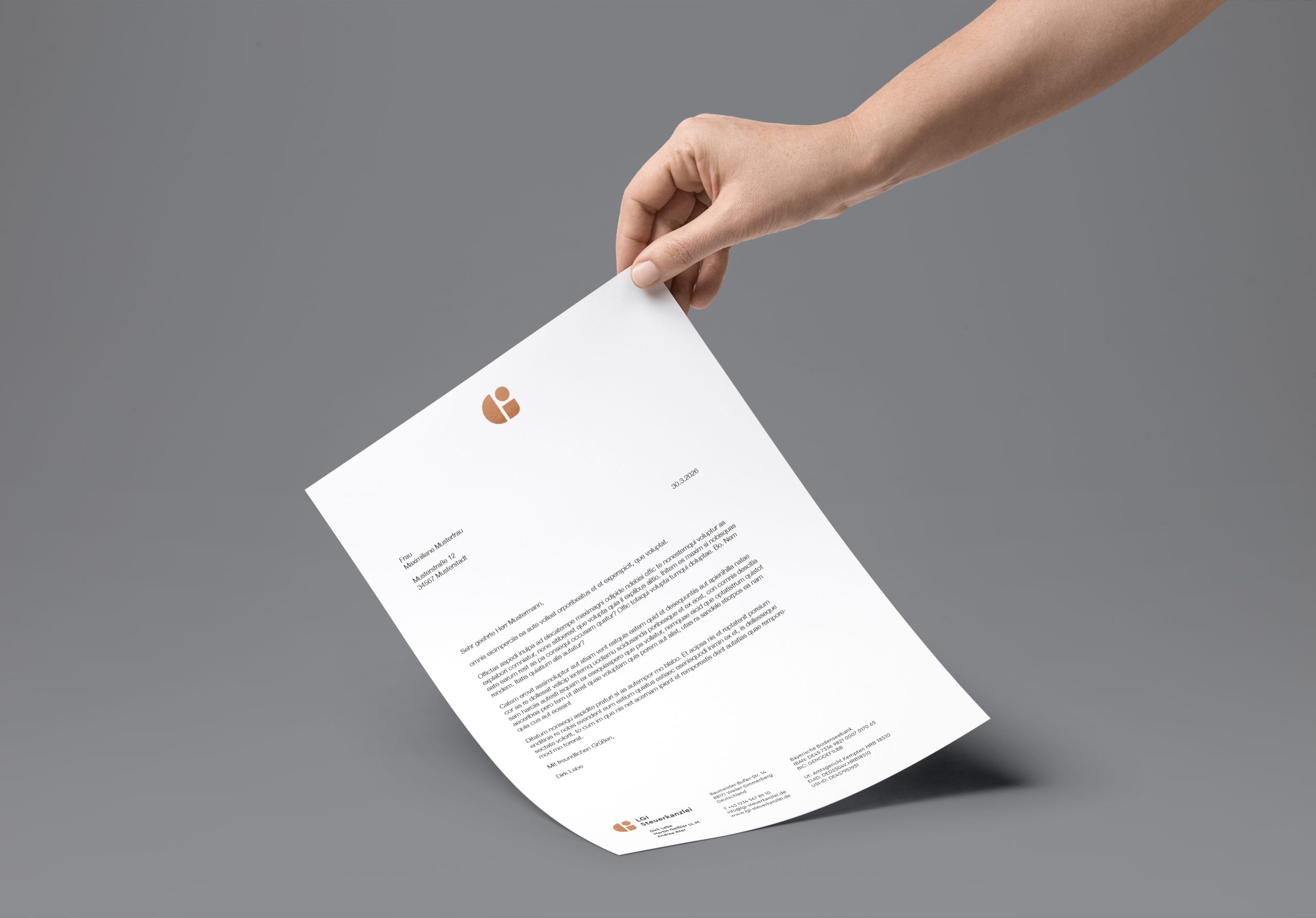 Weißer Briefbogen mit Logo und Datum, gehalten von einer Hand auf blauem Hintergrund.
