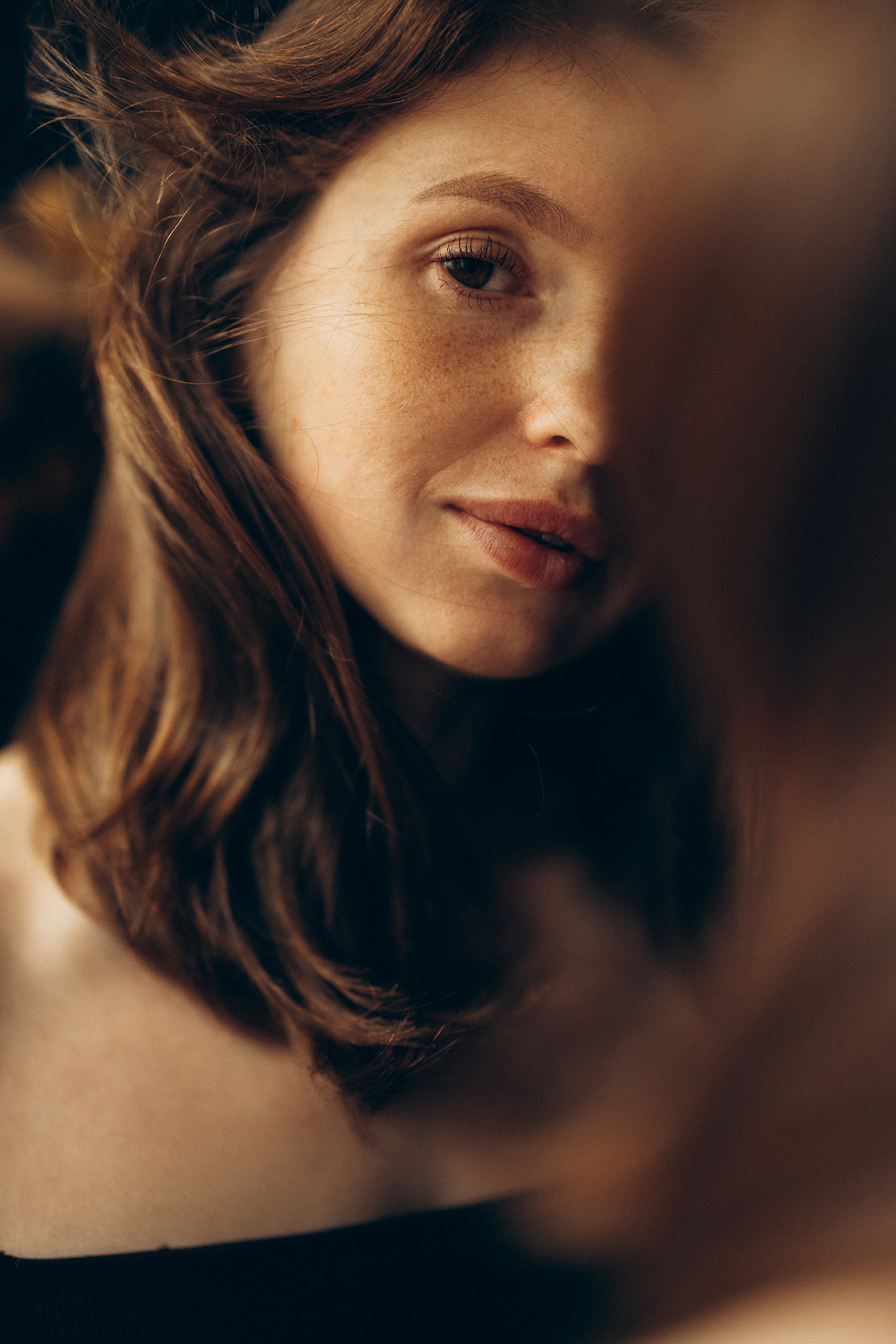Porträt einer Person mit langen, dunklen Haaren und blauen Augen